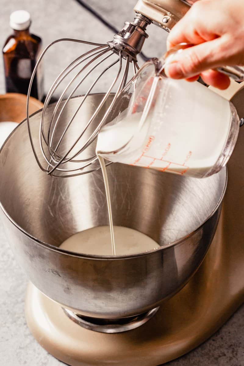 cream being poured into a stand mixer