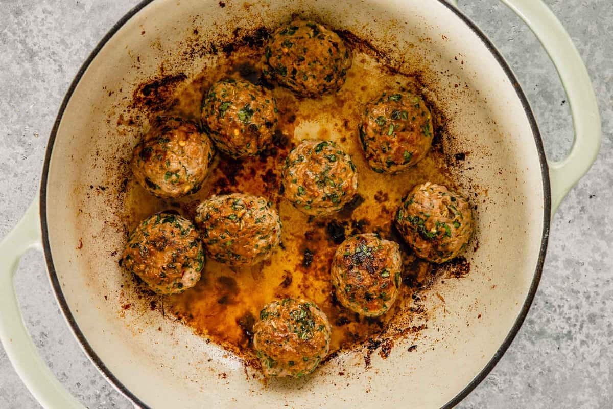 meatballs browning in a Dutch oven