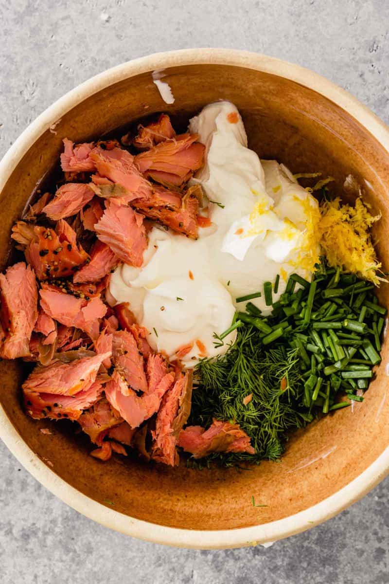smoked salmon, yogurt, lemon zest and herbs in a brown bowl