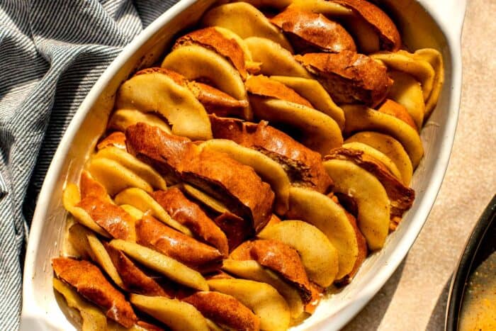 slices of apple and challah layered in a baking dish