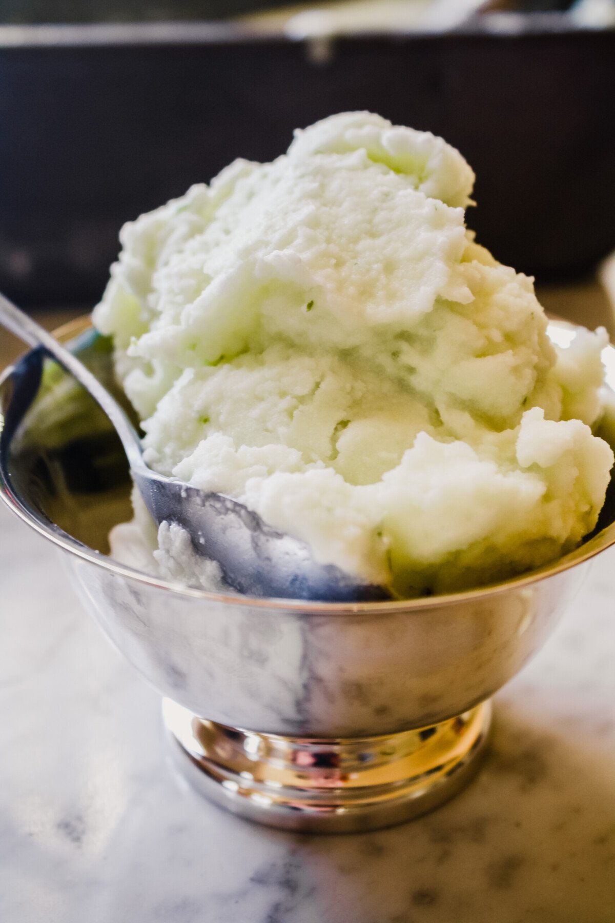 Photograph of sorbet piled high in a silver bowl.