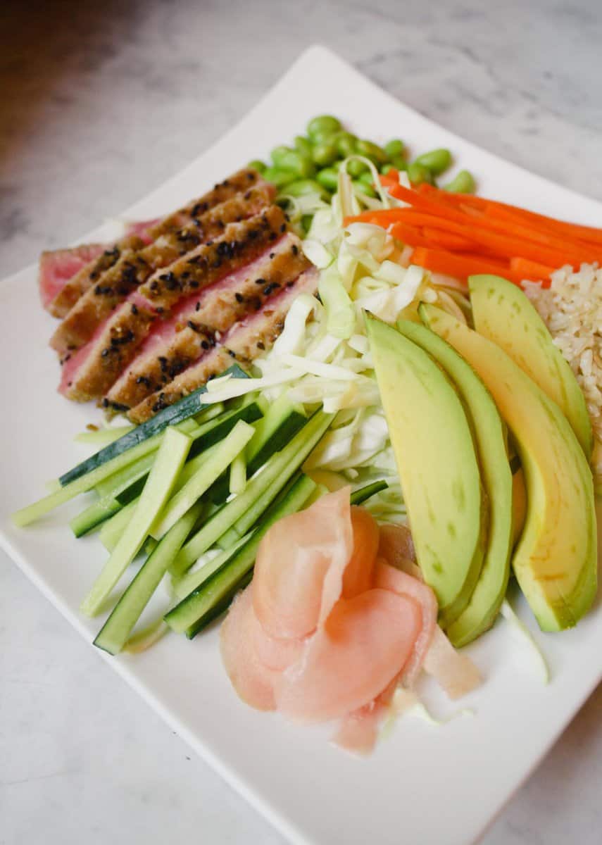 Photograph of a sushi salad arranged on a large white plate.