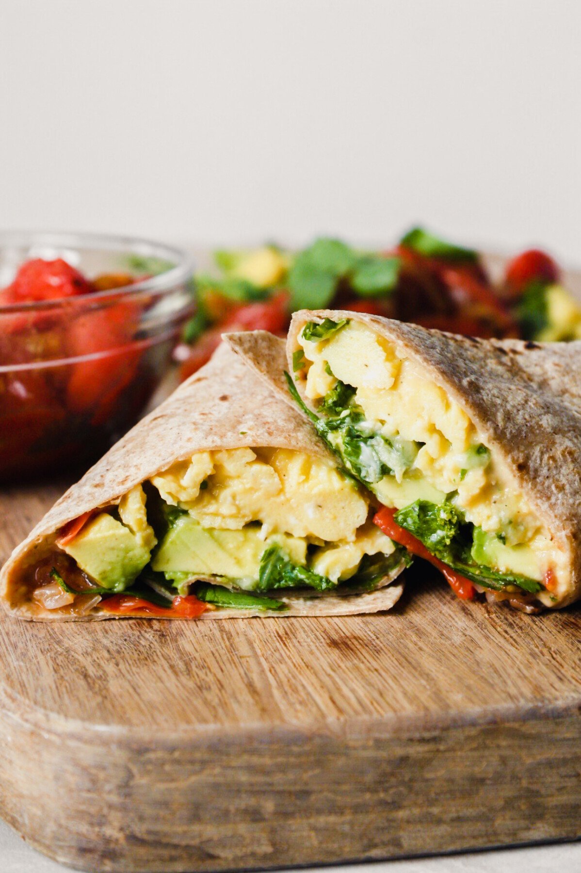 Photograph of a breakfast burrito on a wood cutting board