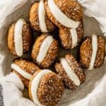pumpkin whoopie pies arranged in a bowl lined with parchment paper