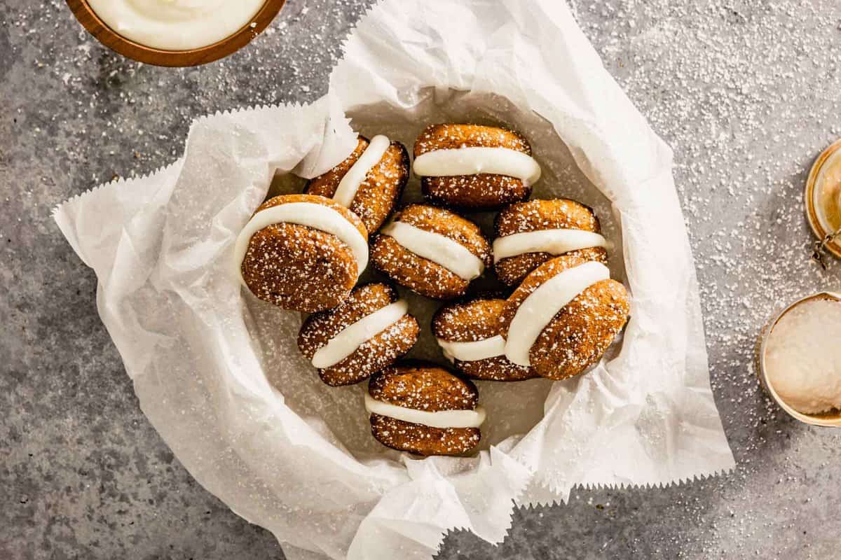 orange-colored whoopie pies arranged in a bowl lined with parchment paper