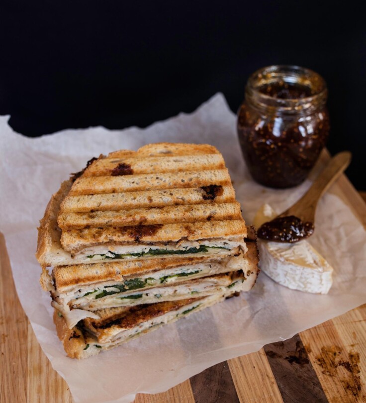 Turkey and Fig Panini set on parchment paper on a cutting board | Zestful Kitchen