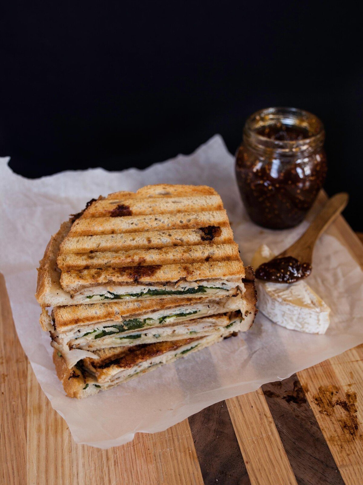 Turkey and Fig Panini set on parchment paper on a cutting board | Zestful Kitchen