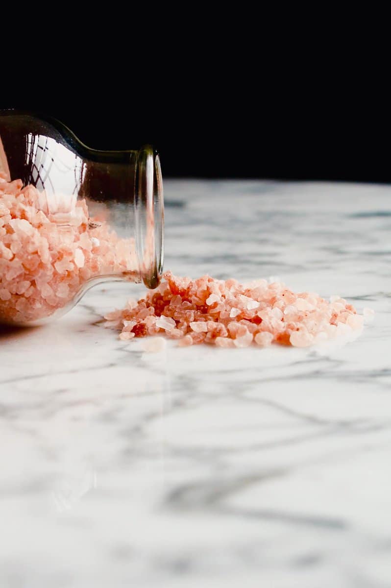 Pink Himalayan salt spilling onto a marble table