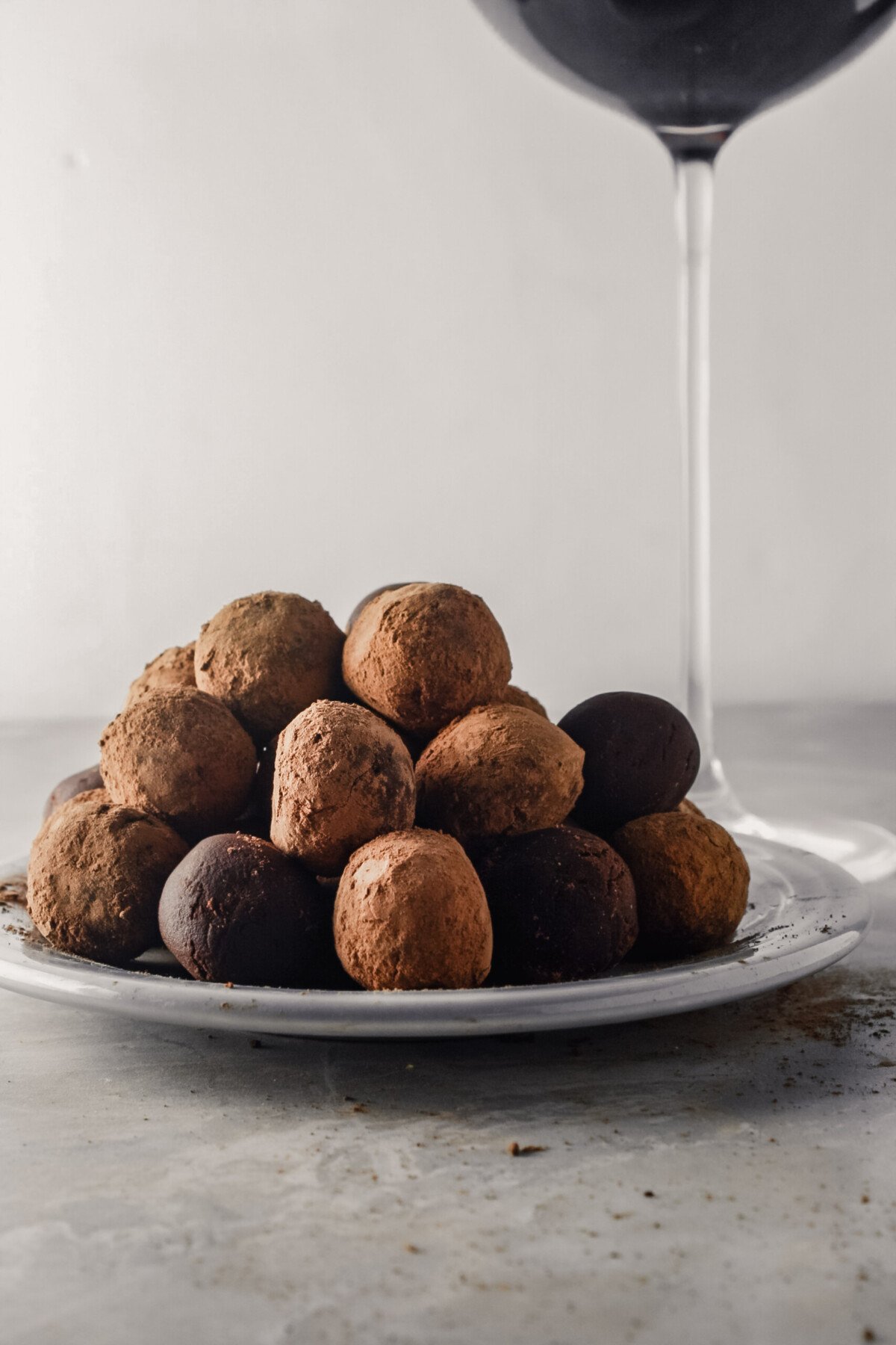 Photograph of dark chocolate truffles stacked on top of a gray plate