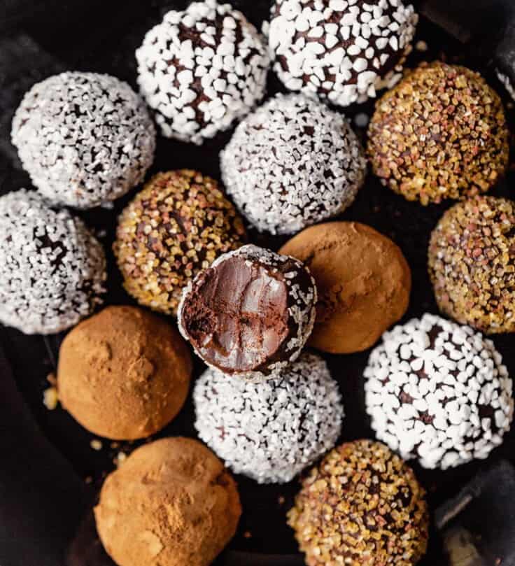 vegan truffles coated in cocoa, sprinkles and sugar arranged on a round blue plate