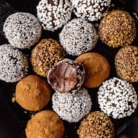 vegan truffles coated in cocoa, sprinkles and sugar arranged on a round blue plate