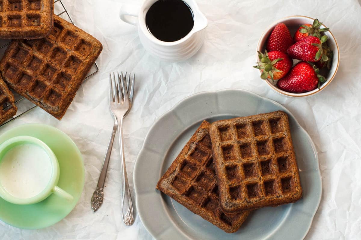 Gluten Free Buckwheat Waffles on a gray plate with milk and strawberries to the side | Zestful Kitchen