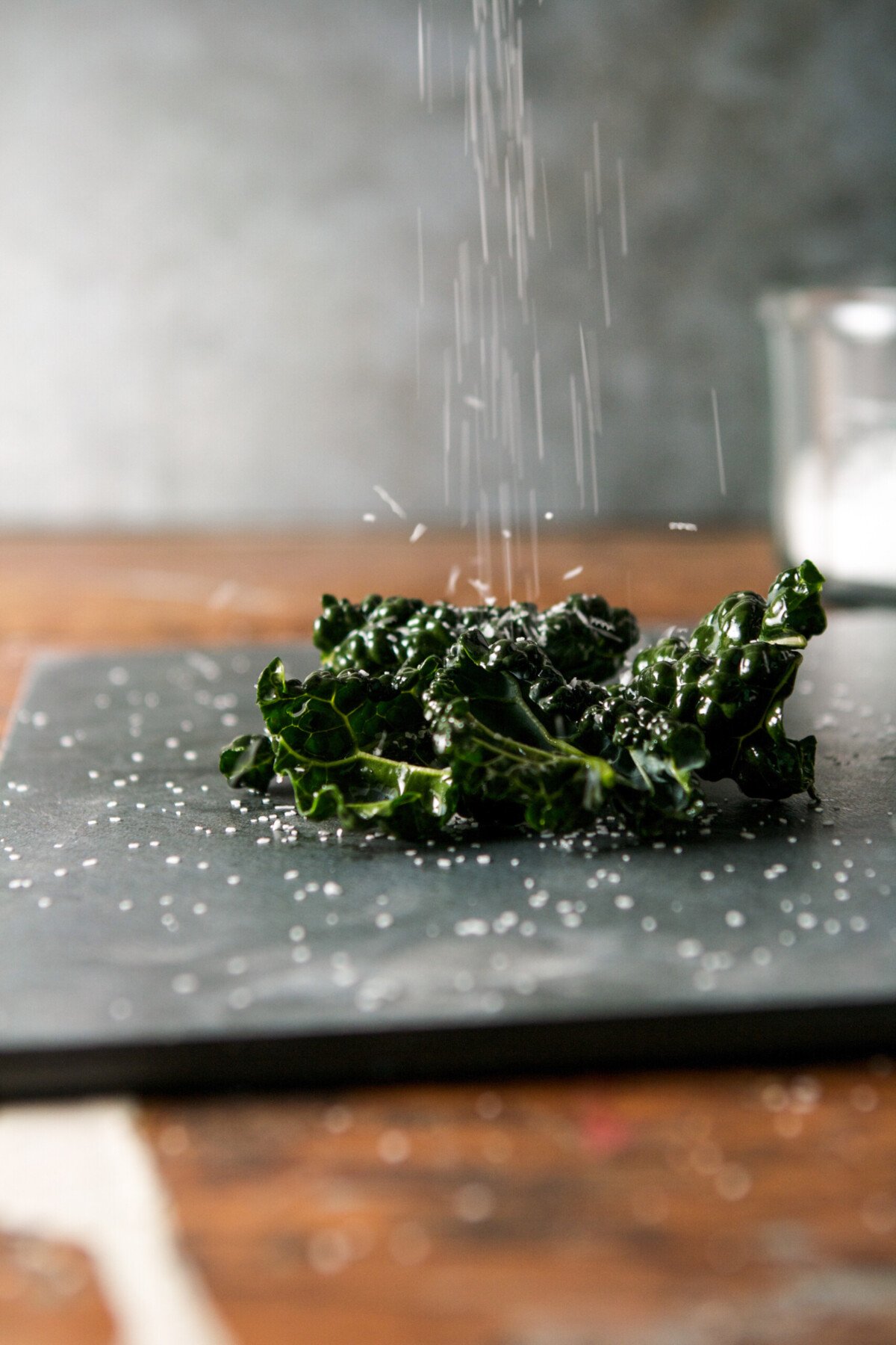 photograph of salt sprinkling down on kale 