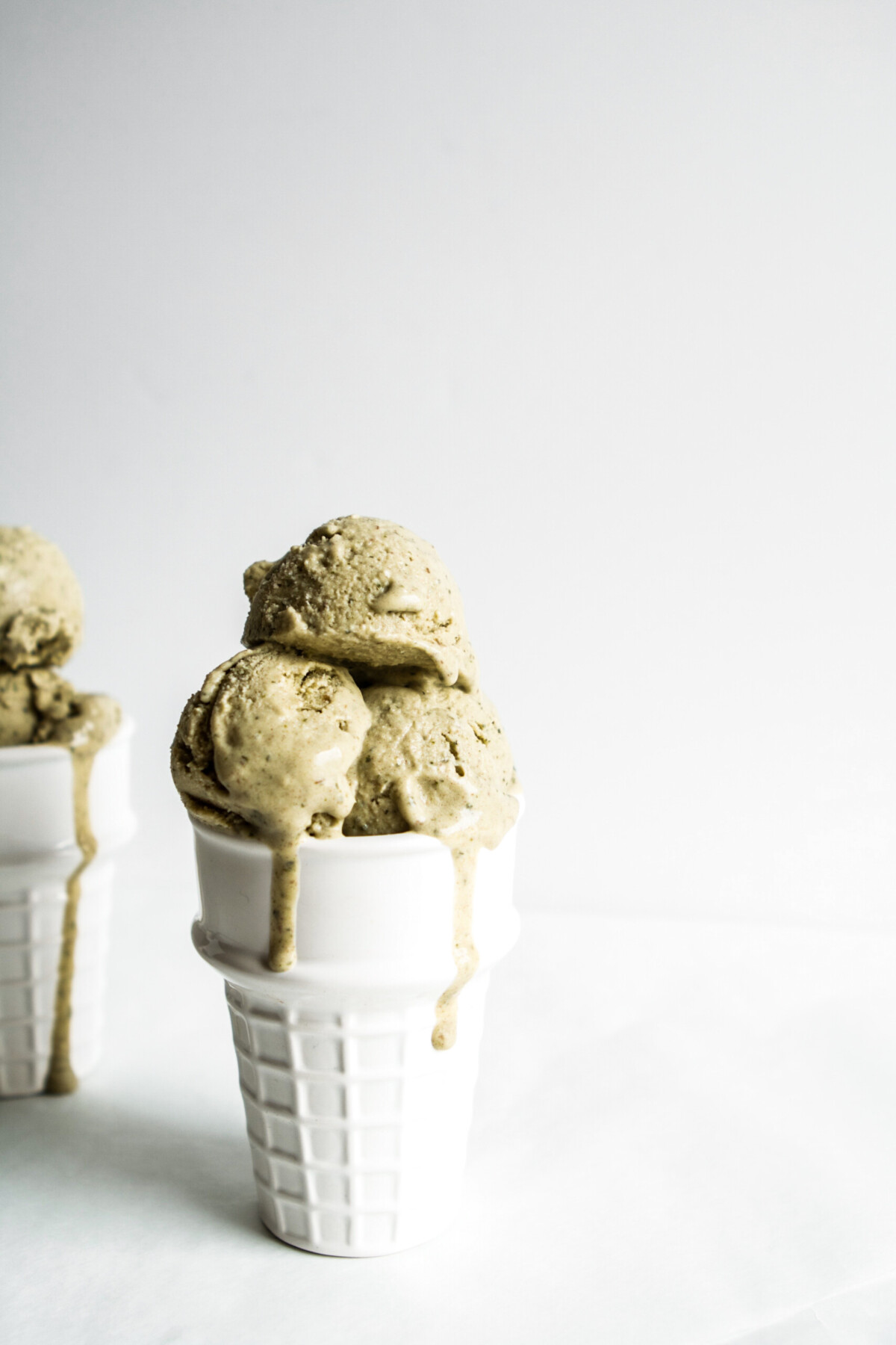vegan mint ice cream scooped into white glass cone