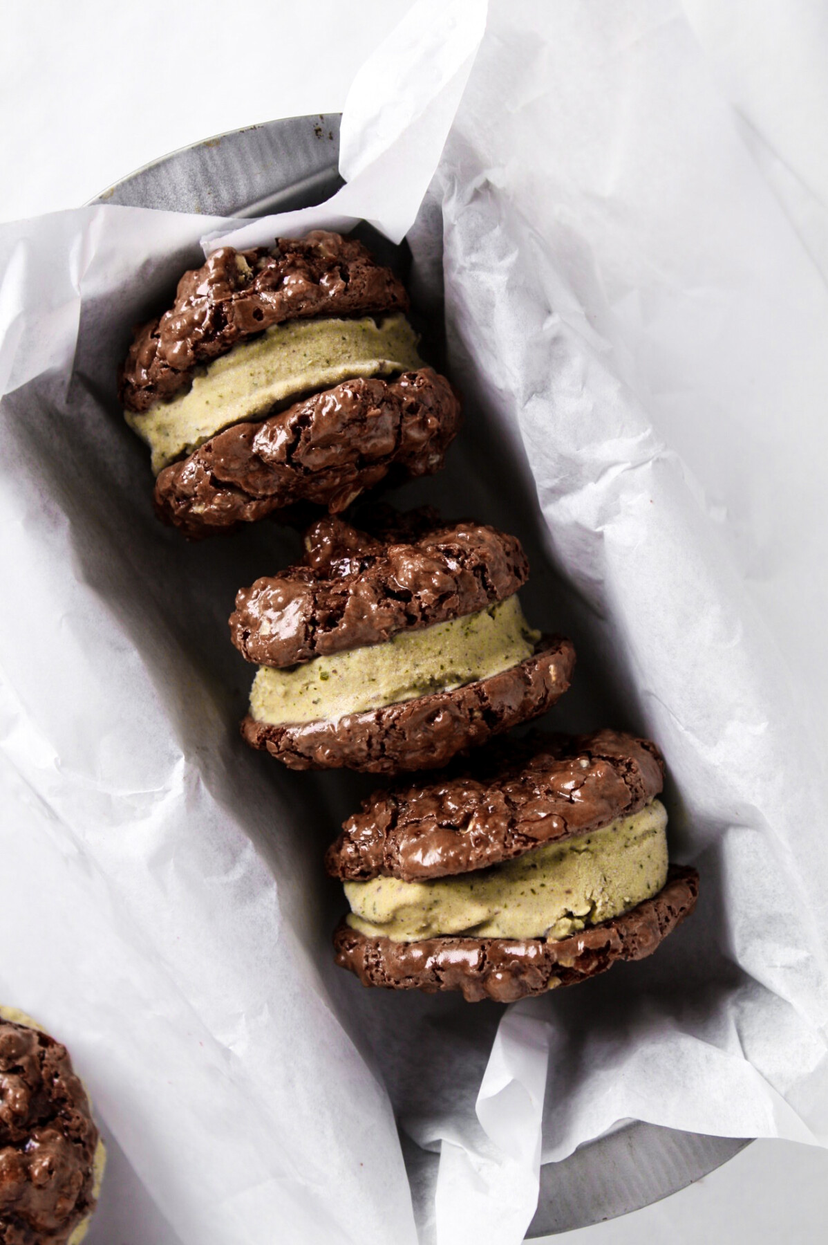 Photo of mint chocolate ice cream sandwiches in a loaf pan with white parchment paper