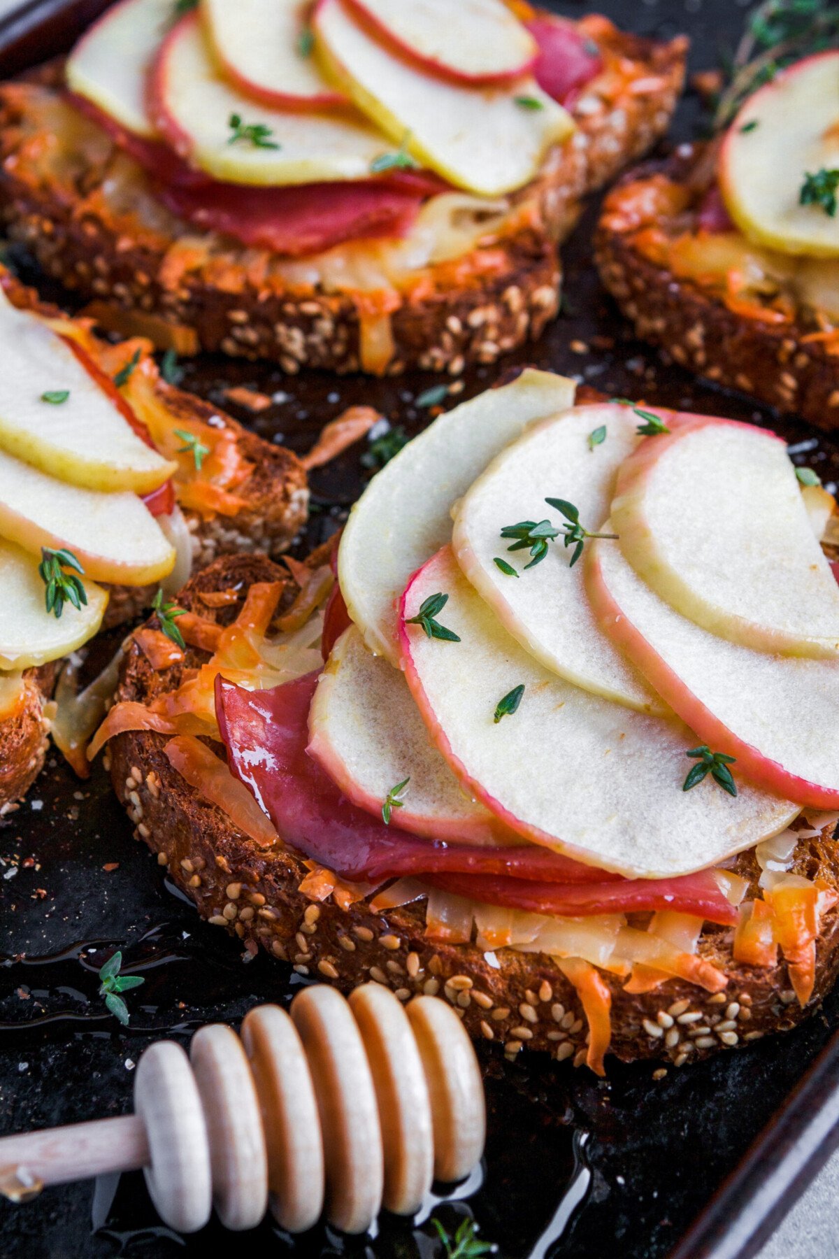 Open faced sandwiches with melted cheese and apple on baking sheet 