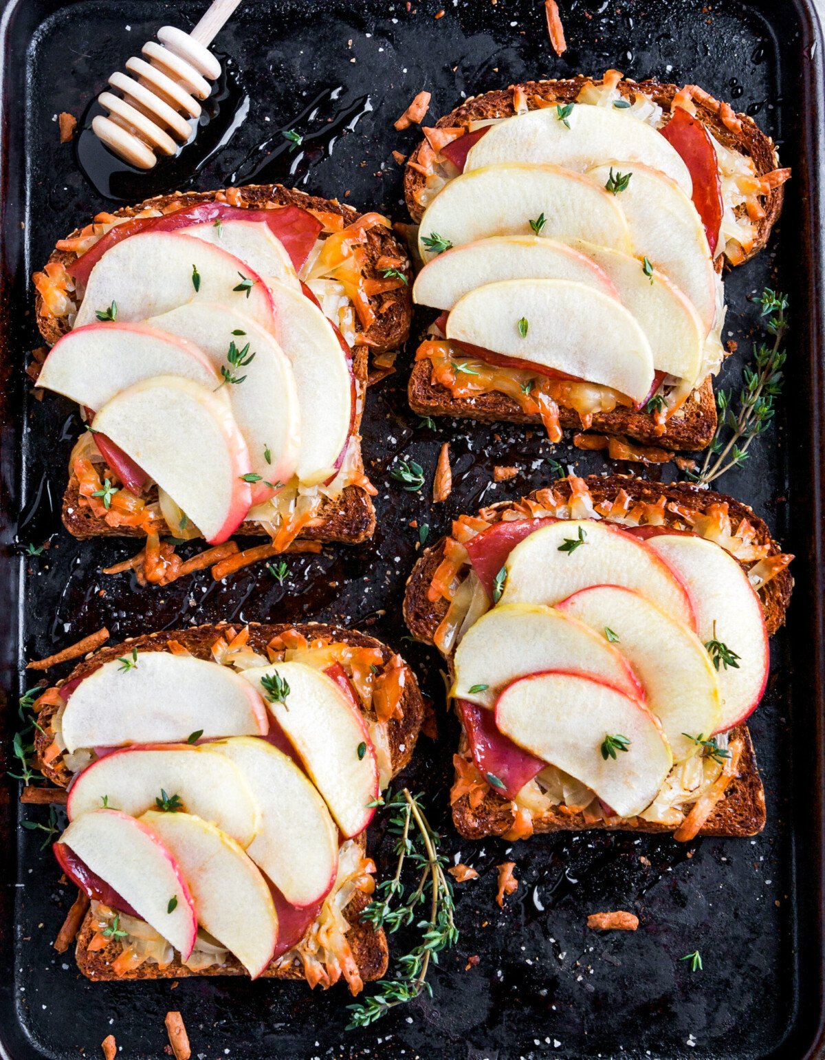 Open faced sandwiches with melted cheese and apple on baking sheet