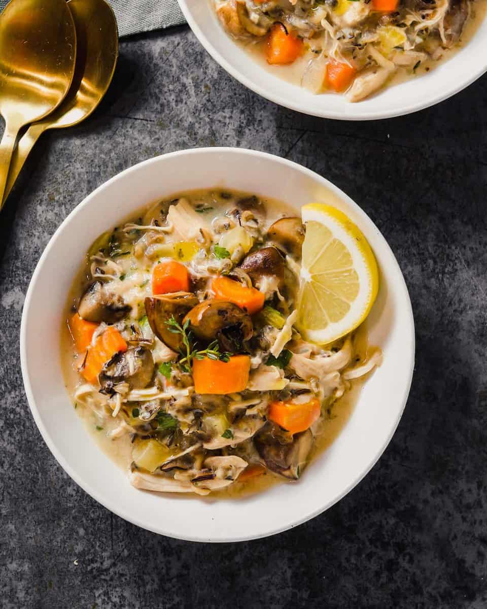 Overhead image of turkey wild rice soup in a white bowl with a gold spoon off to the side