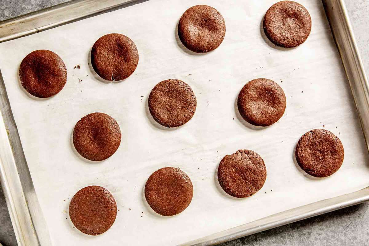chocolate cookie coins on a parchment-lined baking sheet