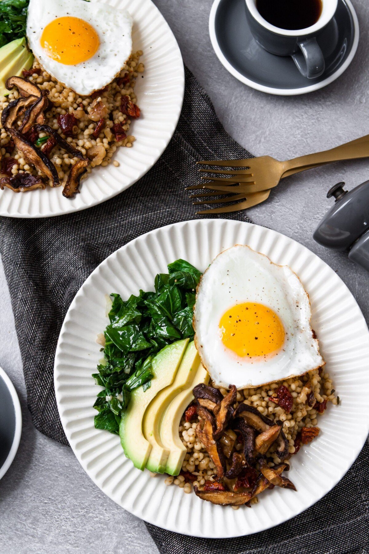 A simple winter breakfast bowl featuring garlicky greens, fragrant sun-dried tomato sorghum, and crispy shiitake mushrooms, topped with avocado and an over-easy egg, this is one healthy and flavorful breakfast. | from Lauren Grant of Zestful Kitchen
