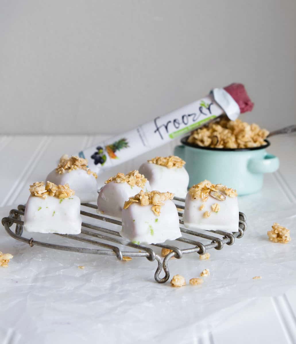 These healthy tropical smoothie bites are enrobed in a silky-smooth lime coconut milk and topped with granola for a satisfying sweet treat. | from Lauren Grant of Zestful Kitchen