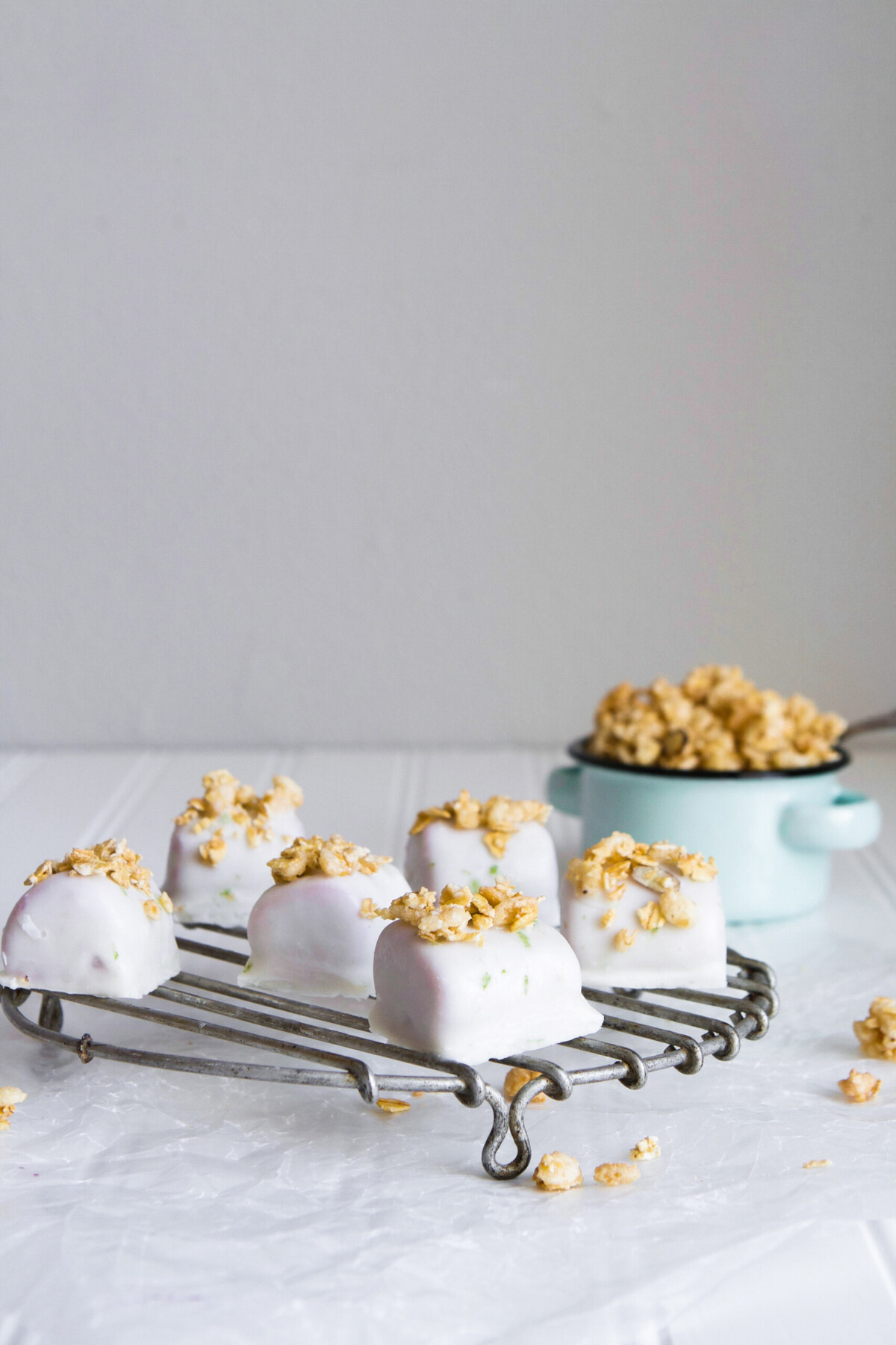 These healthy tropical smoothie bites are enrobed in a silky-smooth lime coconut milk and topped with granola for a satisfying sweet treat. | from Lauren Grant of Zestful Kitchen