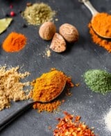 cayenne pepper piled onto a spoon set on a slate board.