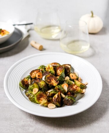 deeply roasted Brussels sprouts on a white plate.