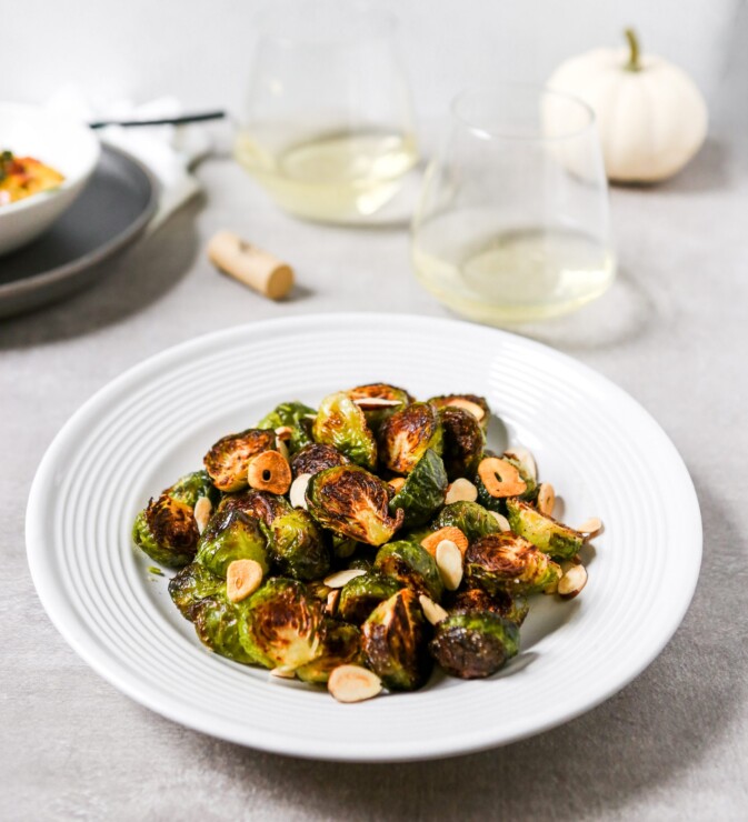 deeply roasted Brussels sprouts on a white plate.