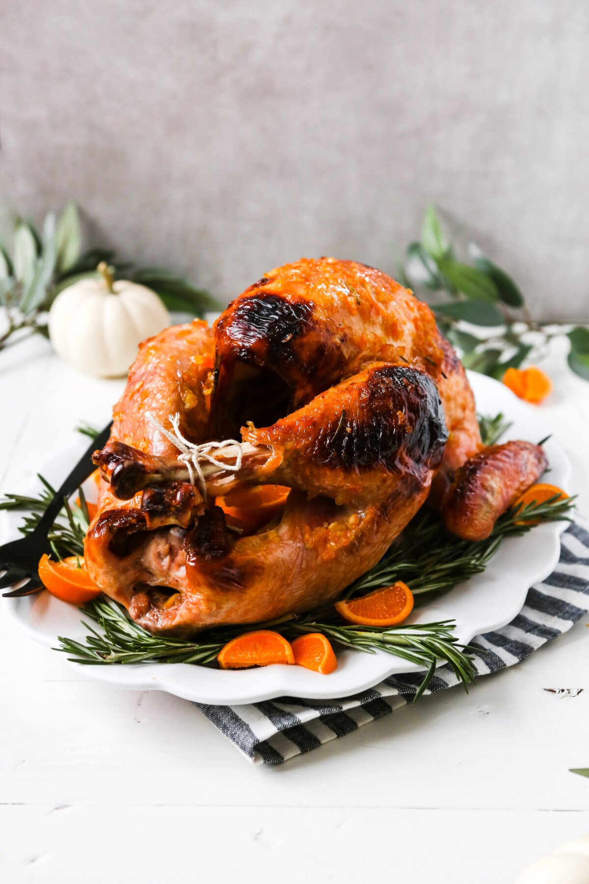 photograph of a whole glazed roast turkey on a large white platter