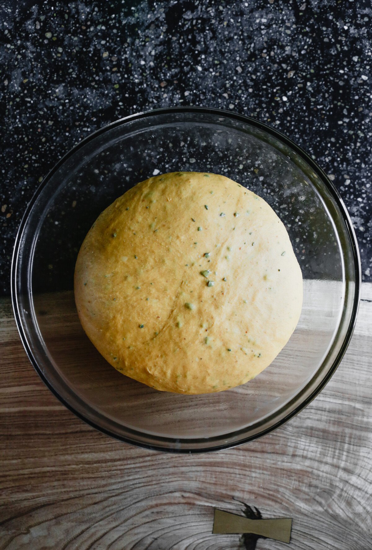 photograph of pumpkin challah dough in a bowl after rising