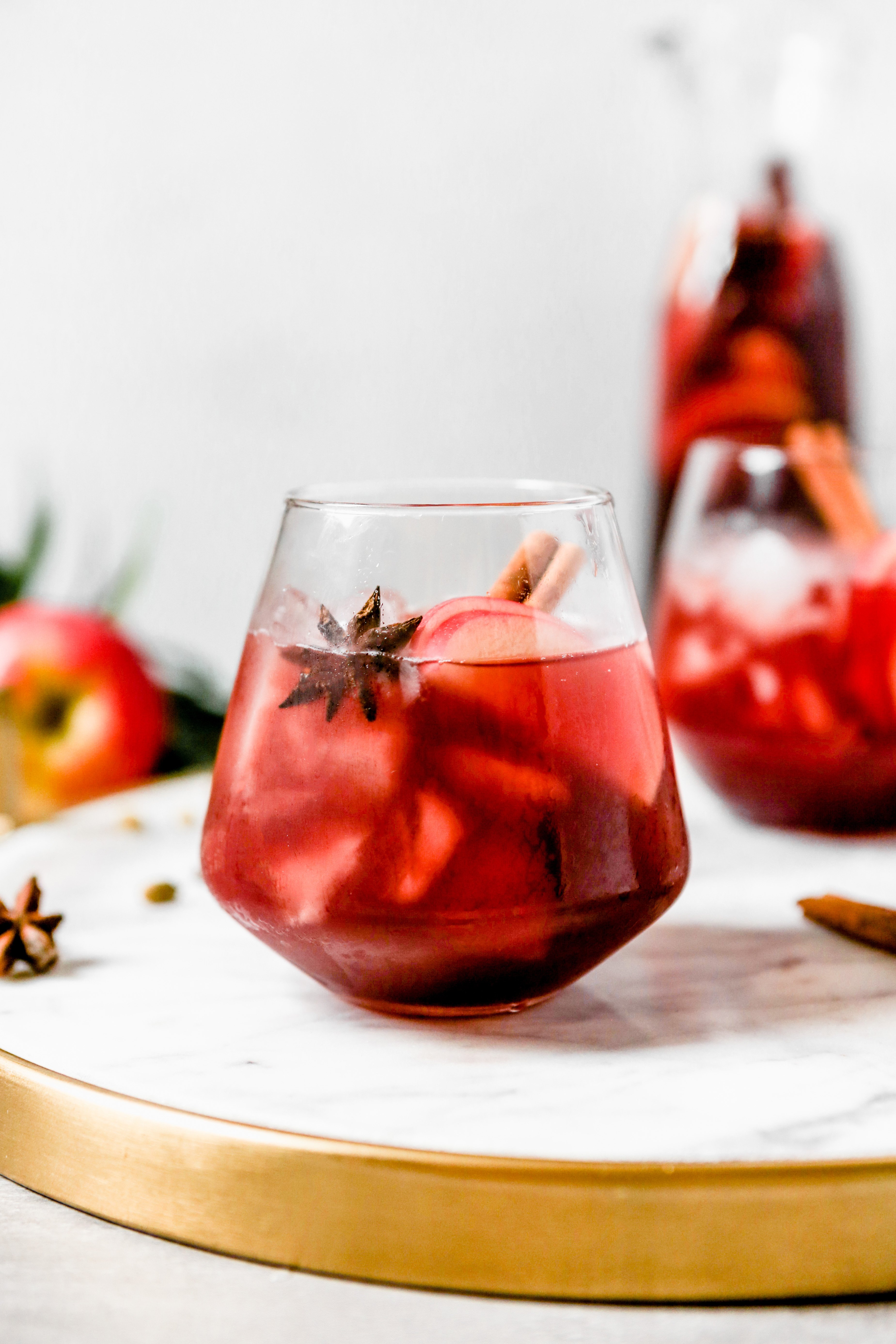 photography of a Red wine apple sangria set on a white marble tray 