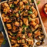 stuffing with mushrooms and swiss chard in a baking dish set on a wood table