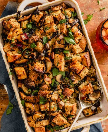 stuffing with mushrooms and swiss chard in a baking dish set on a wood table