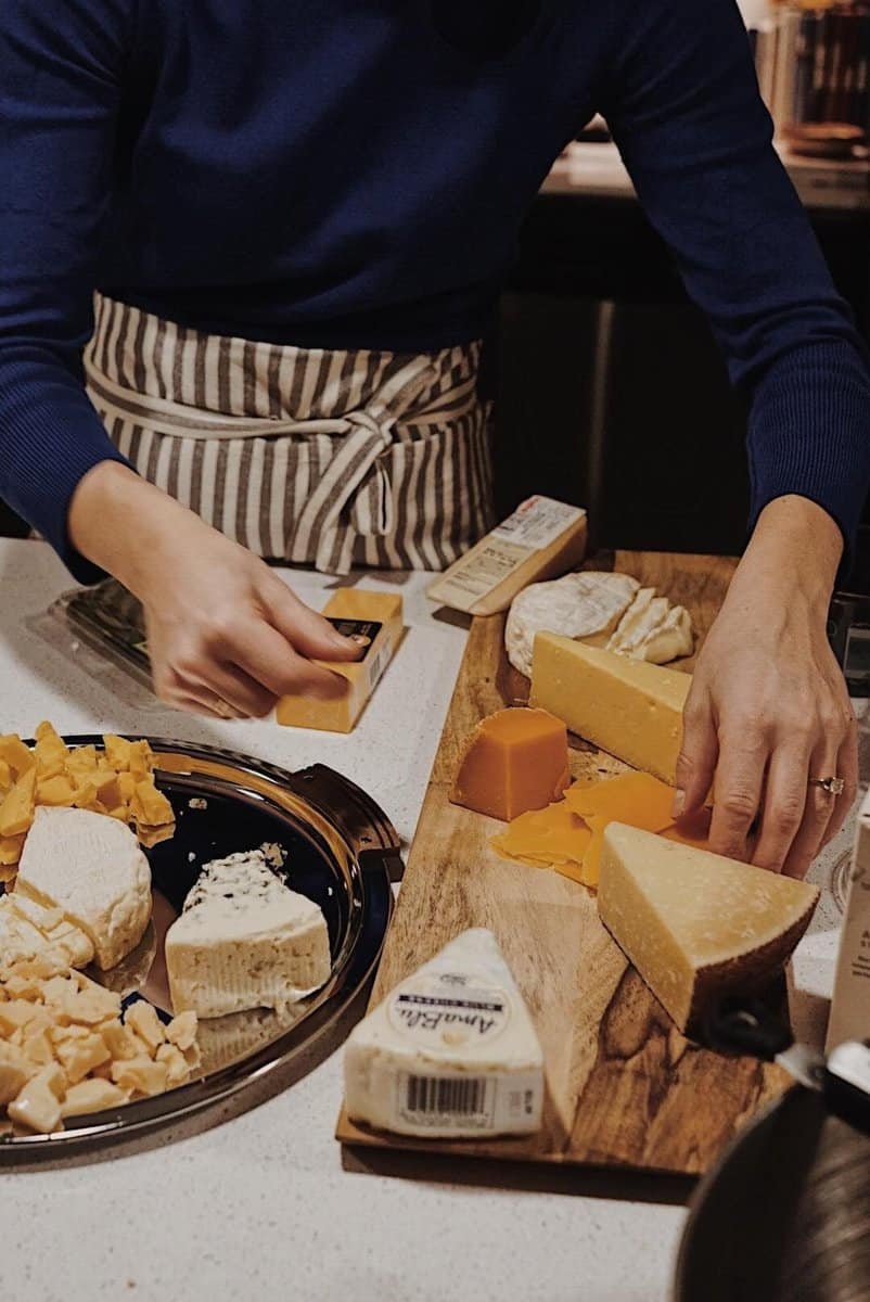 Photograph of someone assembling a cheese board