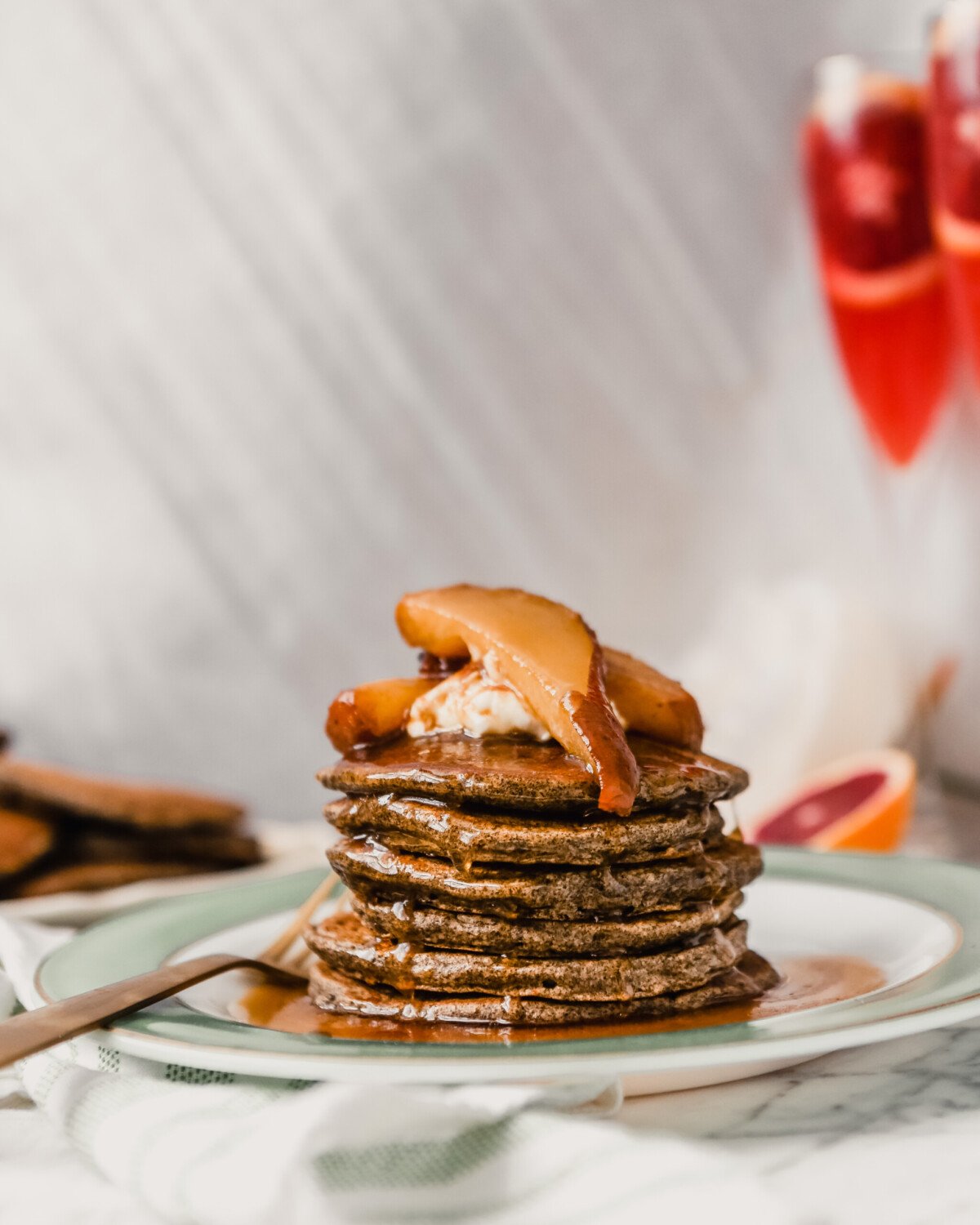 Photograph of a stack of pancakes with maple syrup dripping down them.