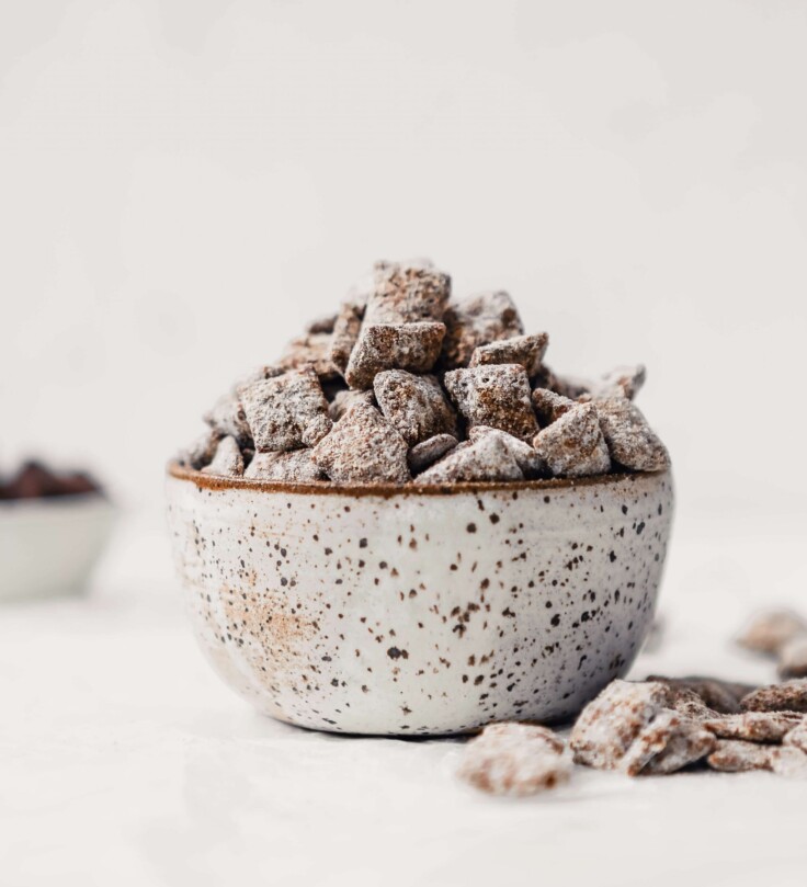 Photograph of healthy puppy chow piled into a spotted pottery bowl on a white table.