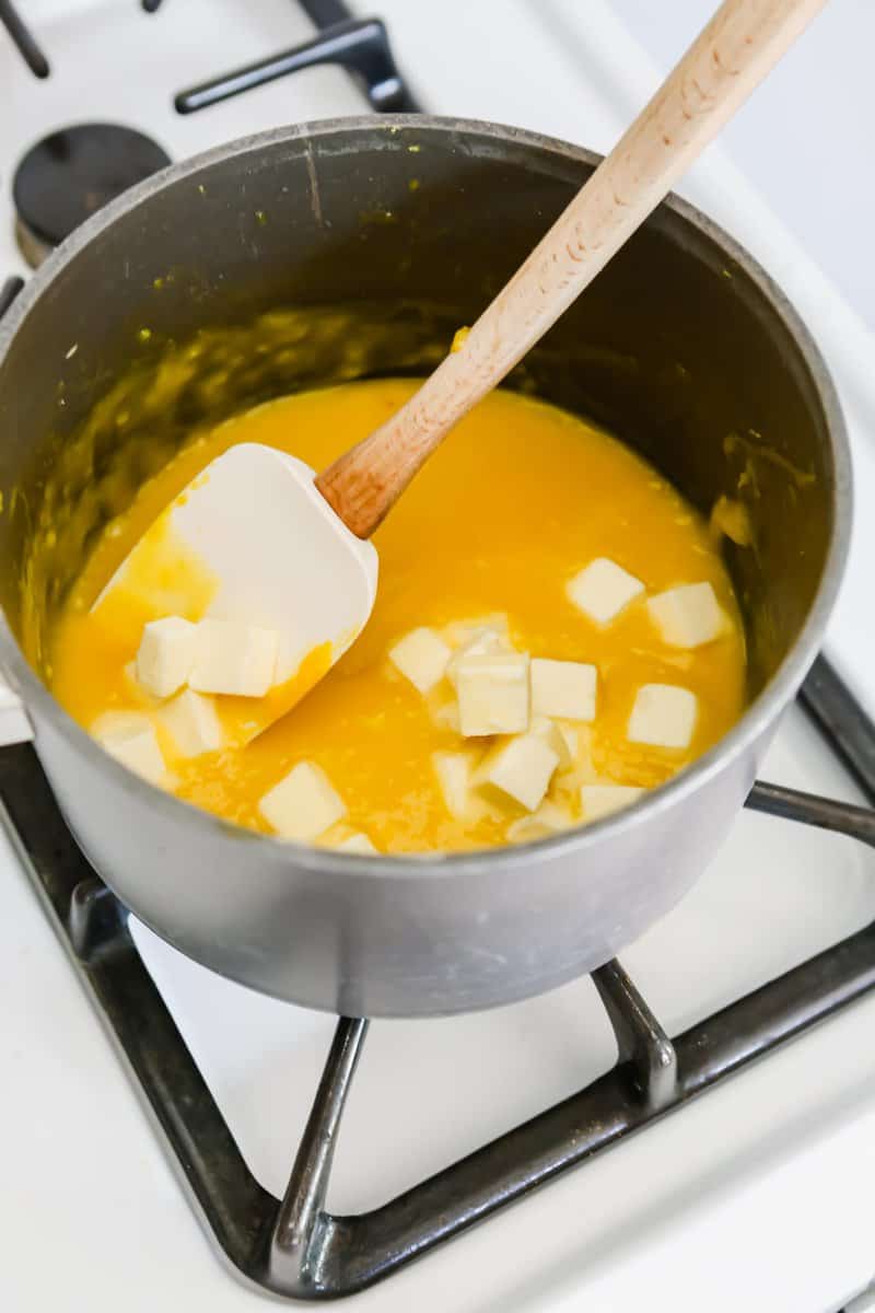 Photograph of diced butter being added to a saucepan with lemon curd