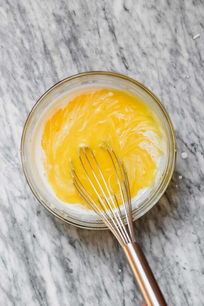 Photograph of cream being whisked into lemon curd