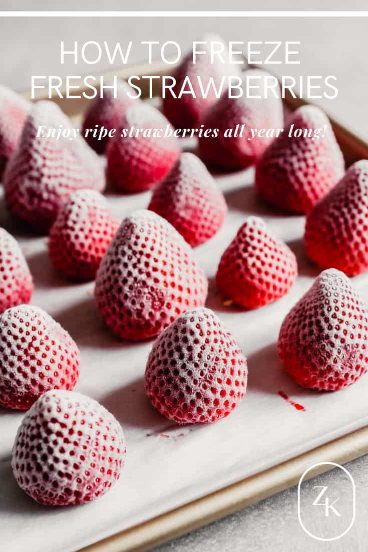 Photograph of frozen whole strawberries arranged on a baking sheet
