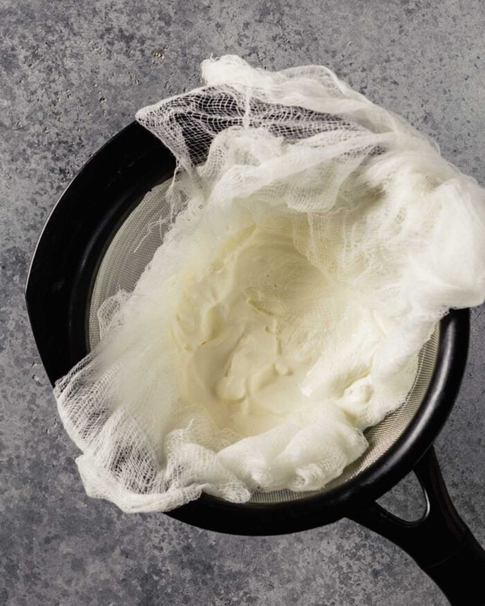 yogurt in a cheesecloth-lined sieve 