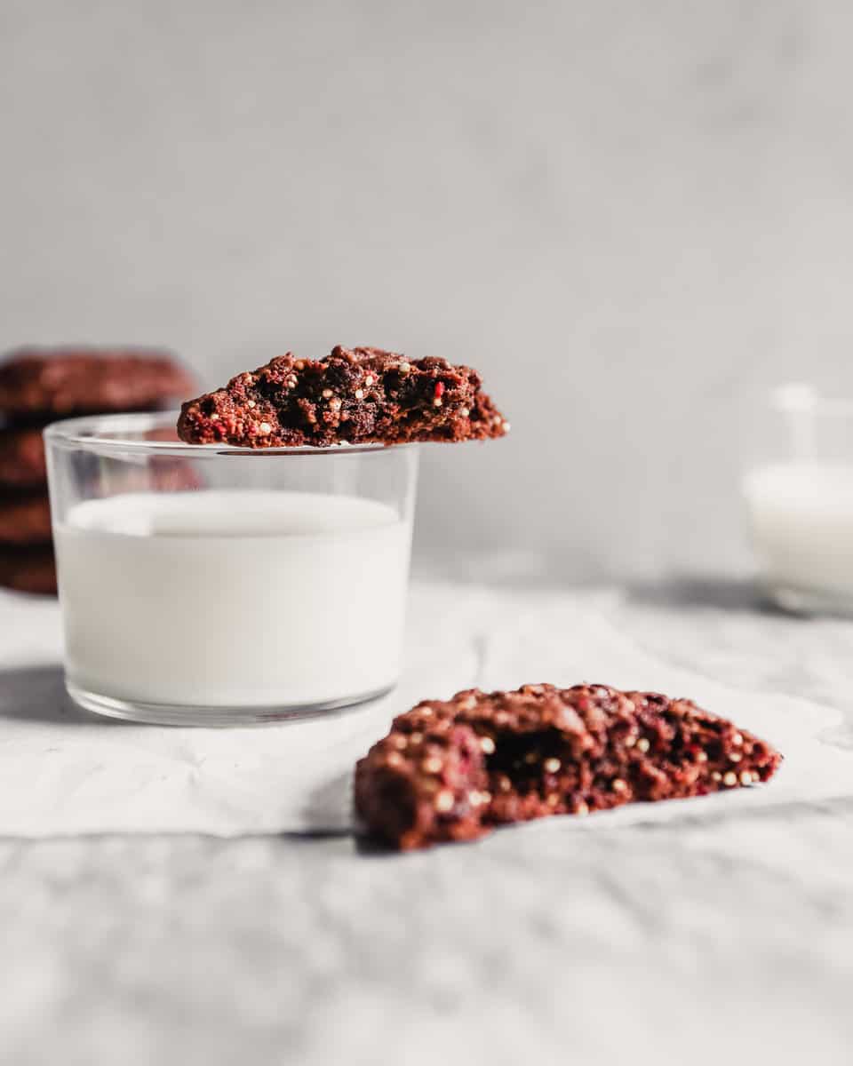 Half of a Mexican chocolate cookie set on top of a glass of milk
