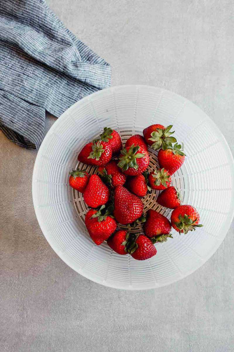 Photograph of fresh strawberries in a plastic basket
