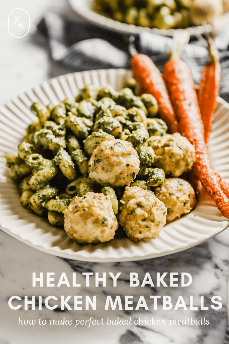 Photograph of chicken meatballs in a white bowl with pesto pasta and roasted carrots