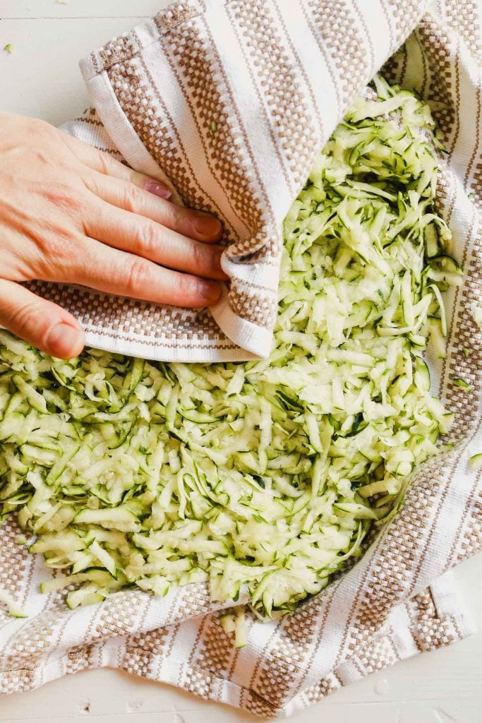 Photograph of shredded zucchini in a kitchen towel