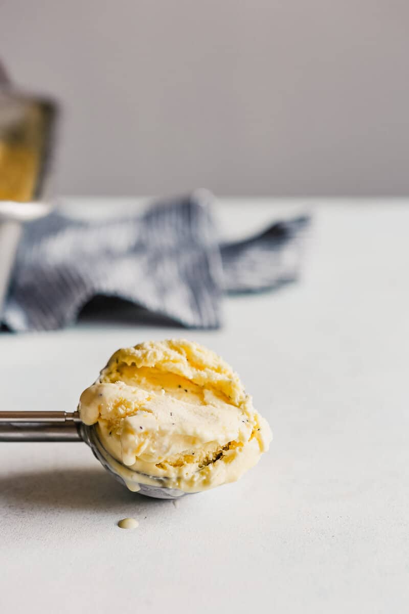 Photograph of a scoop of lemon ice cream in a an ice cream scoop set in a blue table