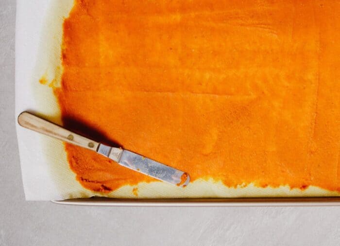 Pumpkin puree spread onto a baking sheet lined with paper towels