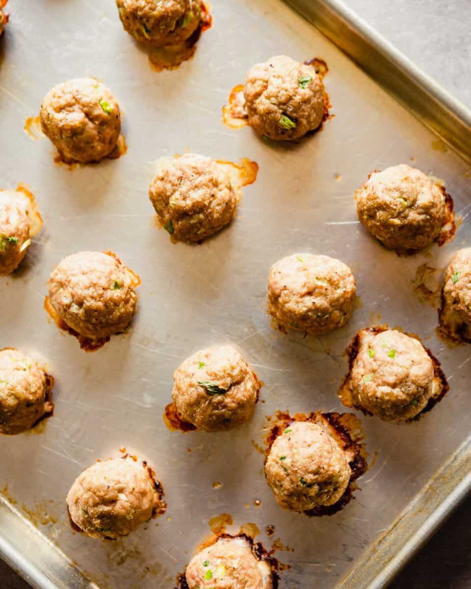 Overhead of baked turkey meatballs on a baking sheet