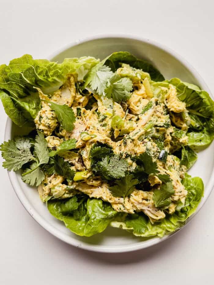 chicken salad on lettuce on a white plate