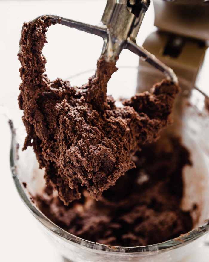 chocolate cookie dough in a stand mixer and on a paddle attachment 